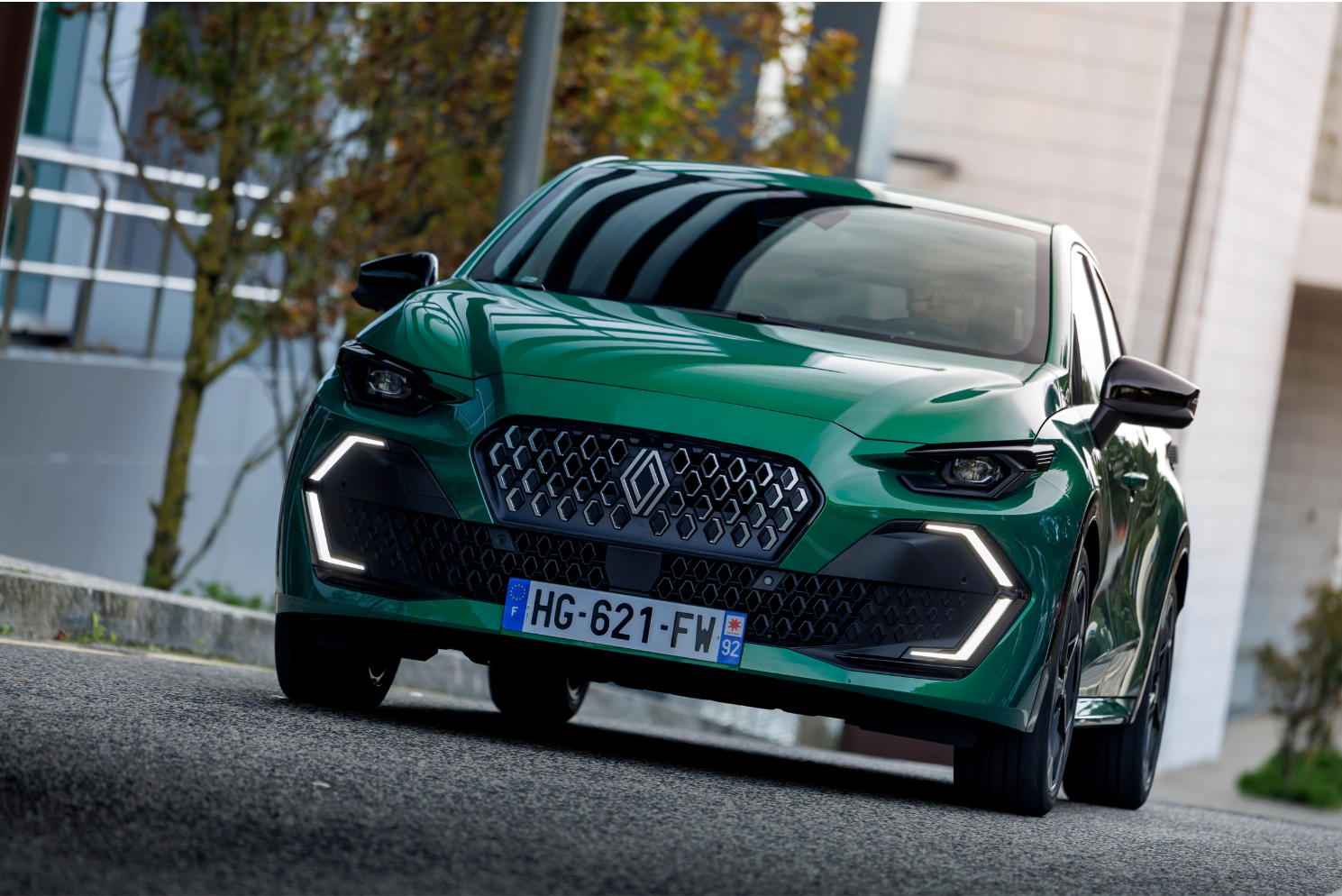 Clio 6 verte vue de face en milieu urbain, avec signature lumineuse LED 