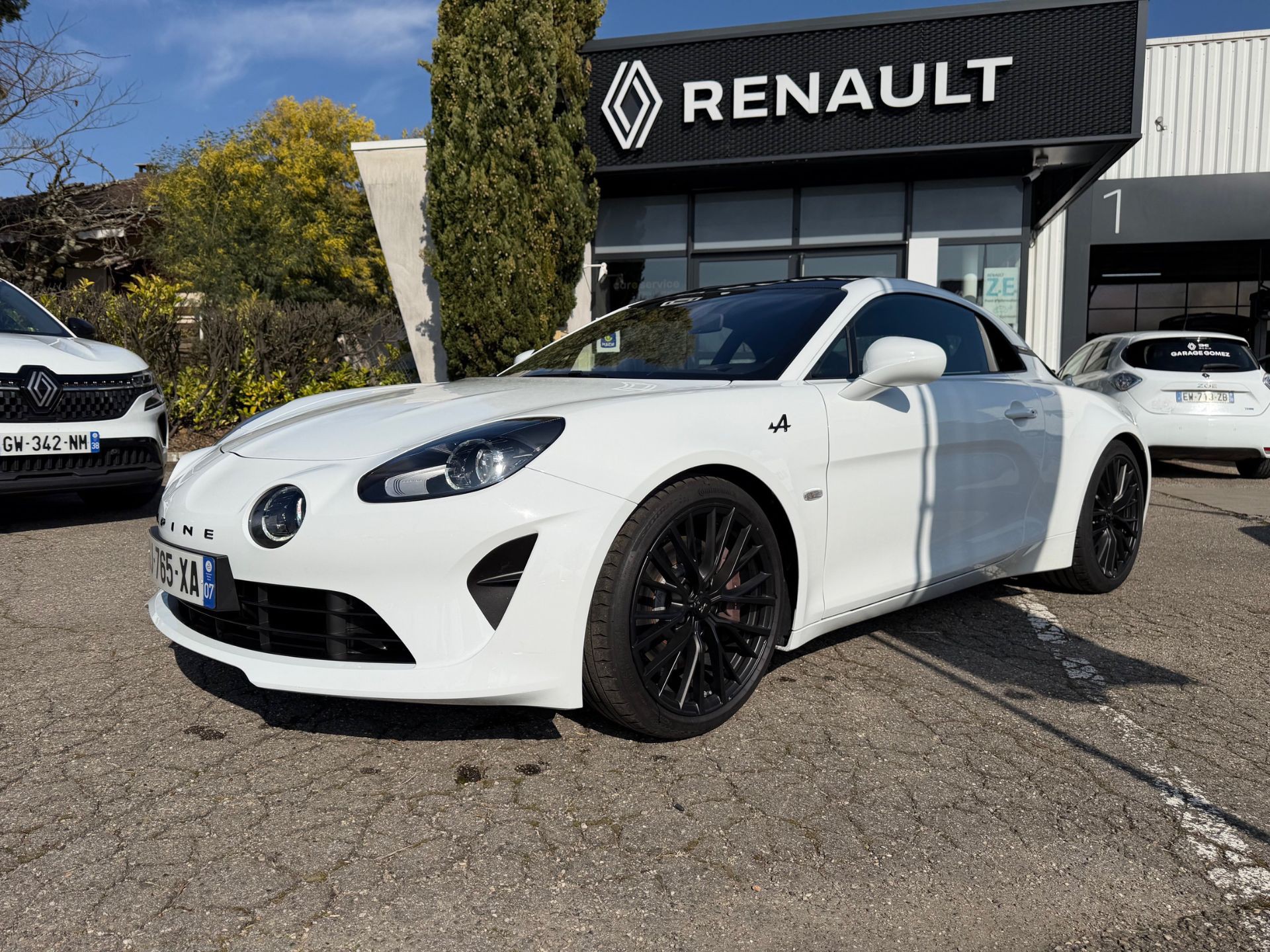 Alpine A110 blanche d&rsquo;occasion expos&eacute;e devant la concession Renault &agrave; Luzinay